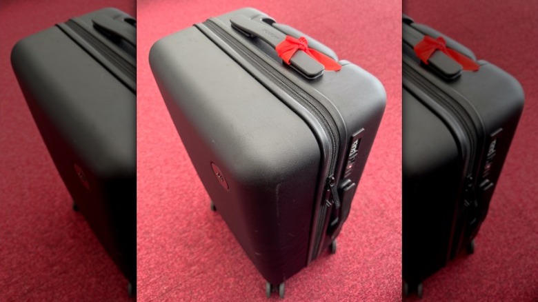 Black Monos suitcase on a red carpet