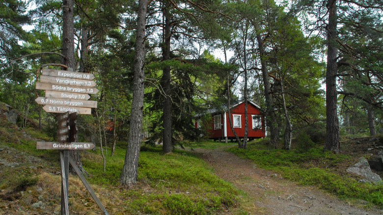 Signpost and red building in forest on Grinda Island in Sweden