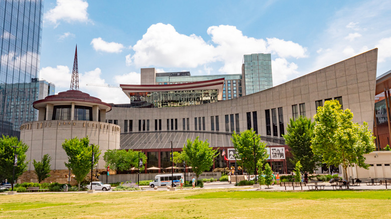 grass lawn in front of a rotunda and long pointed building, sky and clouds