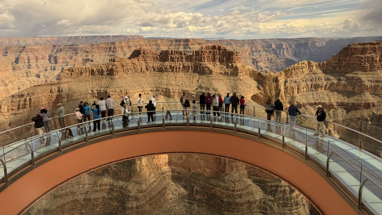 Tourists admiring the Grand Canyon from the Skywalk's glass bridge.