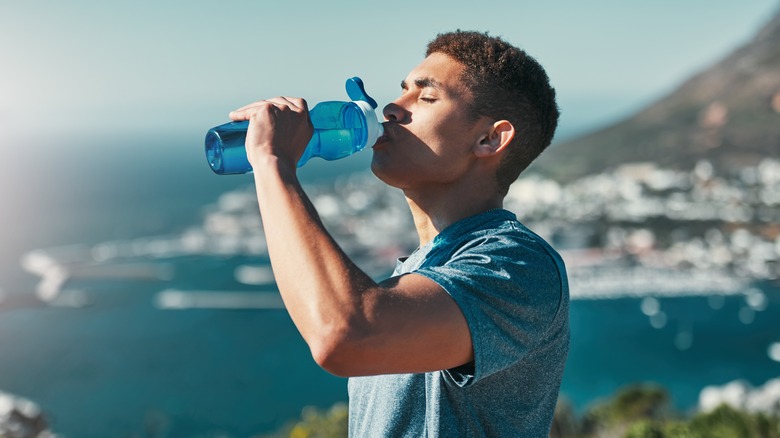 Traveler drinking water out of a reusable water bottle