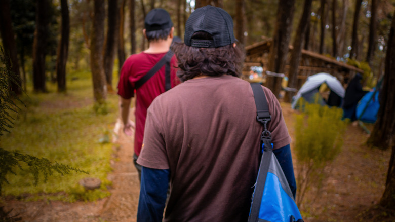 Two hikers carrying gear to a campsite