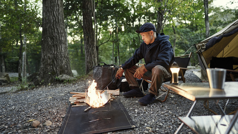 Man poking a campfire