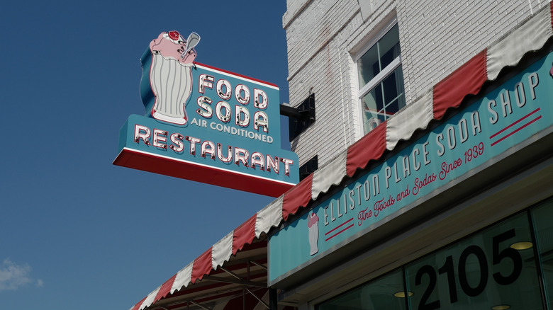The exterior sign of Elliston Place Soda Shop, featuring retro red-and-white stripes and an image of a old-fashioned ice cream soda