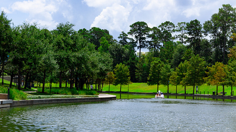People boating on the water surrounded by trees in The Woodlands, TX