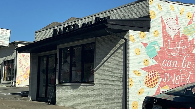 The exterior of Baked on 8th in Nashville, showing the bakery's logo and a mural reading "Life can be sweet"