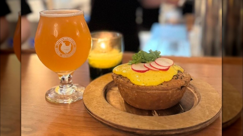 A beer sits next to a savory pie at Fat Hen Brewing Company in Exeter, New Hampshire