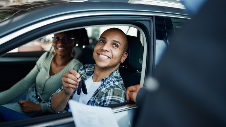 Man in a rental car handing over keys