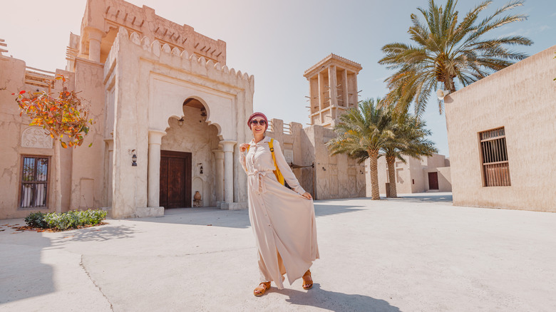 Young covered woman in Dubai against cultural buildings