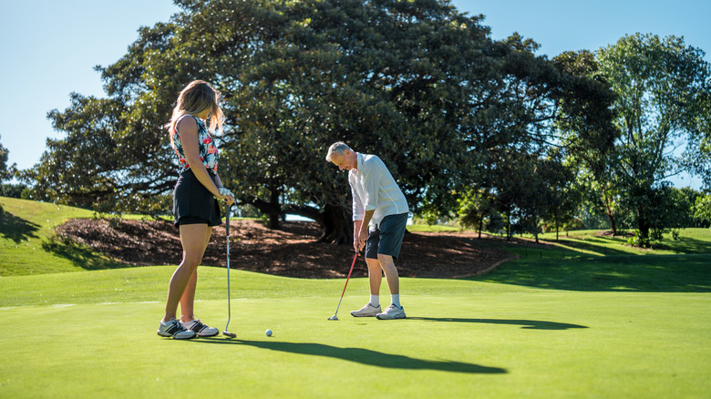 A man and woman golfing