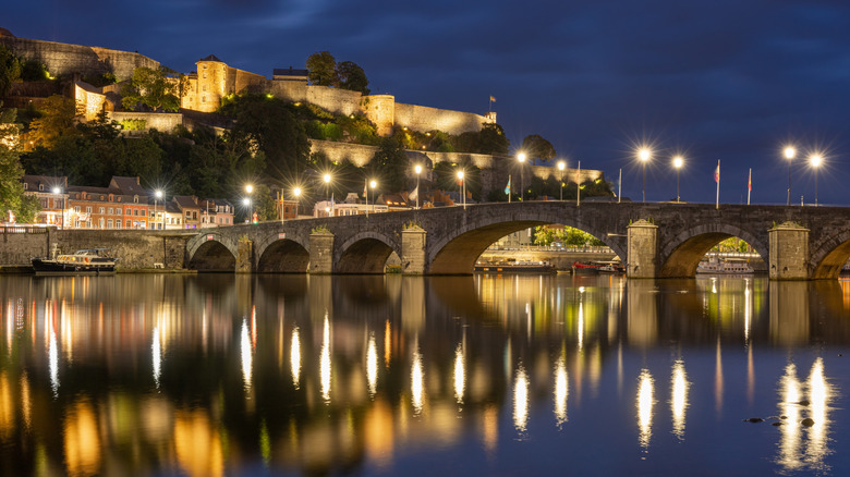 Nighttime view of lights reflecting into water from Namur citadel