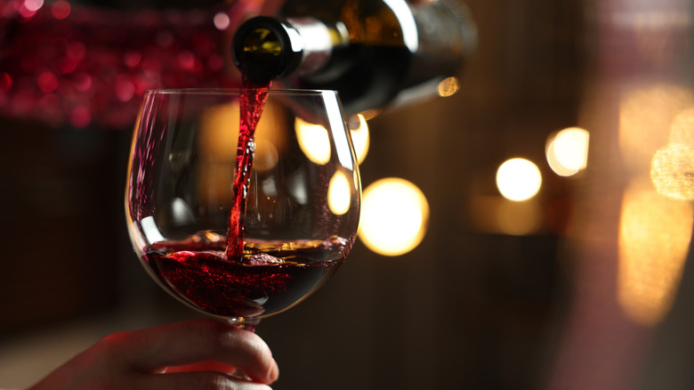 Red wine poured into glass at tasting