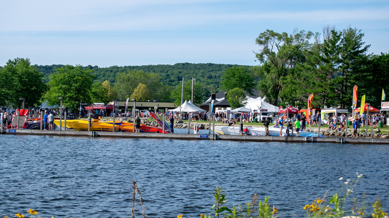 Kayaks lined up by the water in Boyne City during the day.