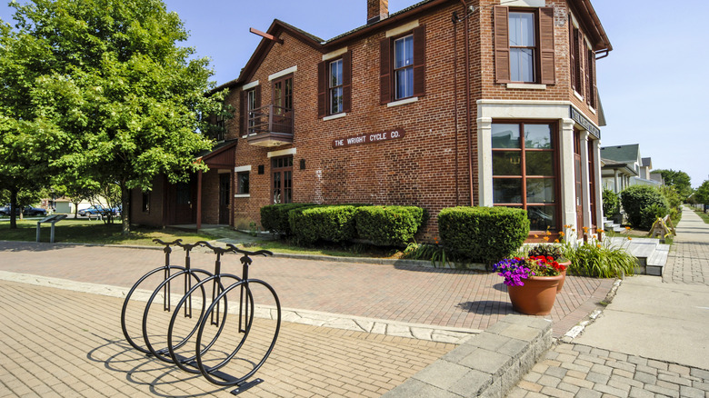 Sculpture of bikes outside historic brick building at wright cycle co