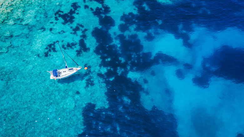 A boat bobs in the blue seas just off Fteri Beach, Kefalonia