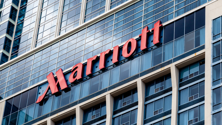 Floor-to-ceiling windows and a red "MARRIOTT" sign at the entrance to a Marriott hotel.