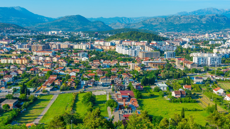 An aerial view of the colorful buildings and mountains in Podgorica, Montenegro