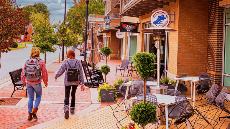 The backs of two people strolling in downtown Holly Springs