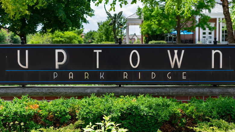 A sign for Uptown Park Ridge with white lettering on a black background