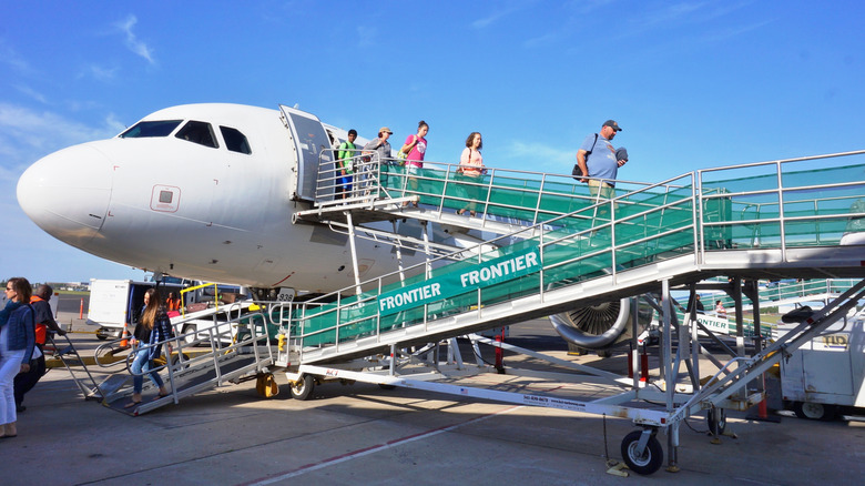 Passengers disembarking from a Frontier Airlines flight outside at Trenton-Mercer Airport.