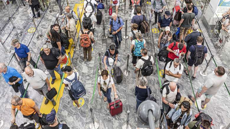A long line of air travelers at an airport security checkpoint