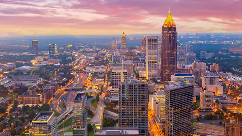 The Atlanta skyline at dusk with pink skies and glowing city lights.