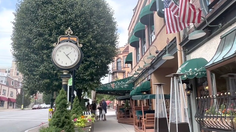 View of a street in Conshohocken outside restaurant with large street lamp clock showing Conshy time