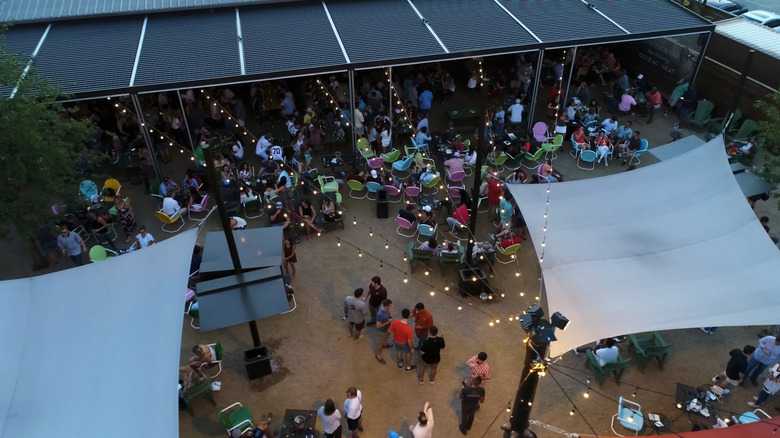 People gathered on the patio around picnic tables at Kirby Ice House