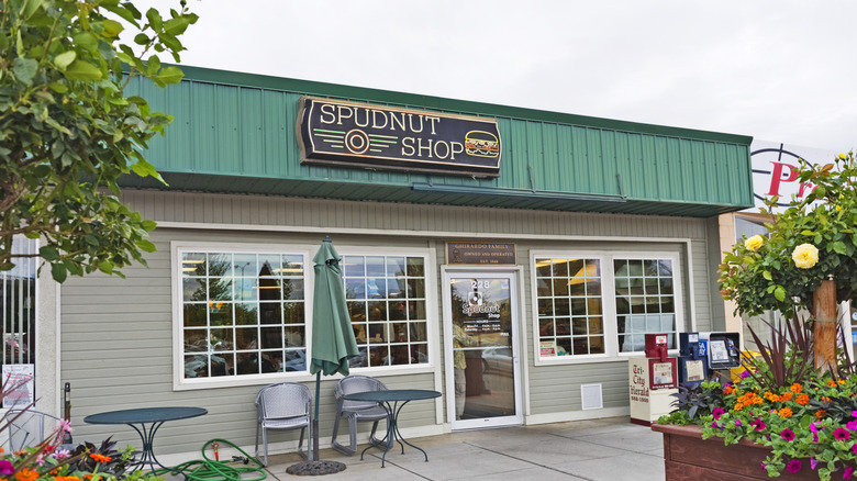 Spudnut Shop old-school sign green facade framed by flowers