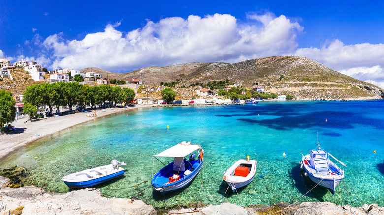 a beautiful view of a beach and boats on the island of Kalymnos, Greece