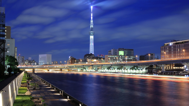 View of Tokyo Sky Tree and Kuramae bridge with a walkway along the river at night
