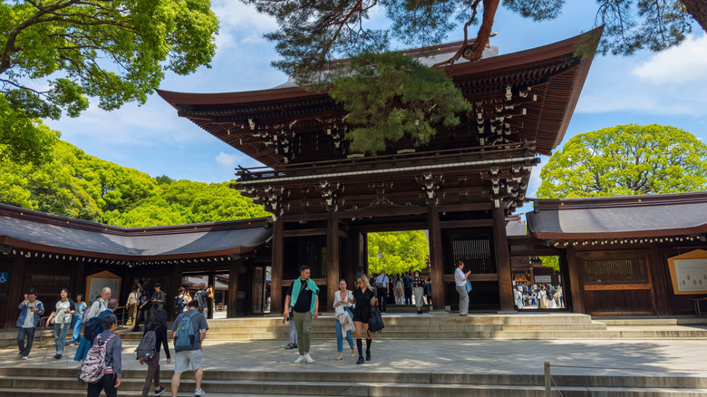 People entering and exiting Meiji Shrine surrounded by trees, Tokyo, Japan