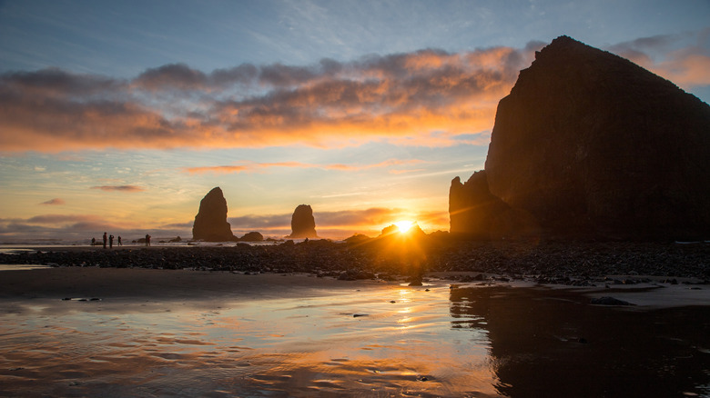 Cannon Beach, Oregon at sunset with large rock in the foreground