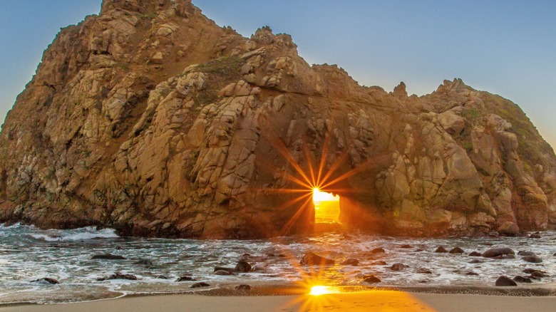 Rock formation at Pfeiffer Beach with sunset shining through hole
