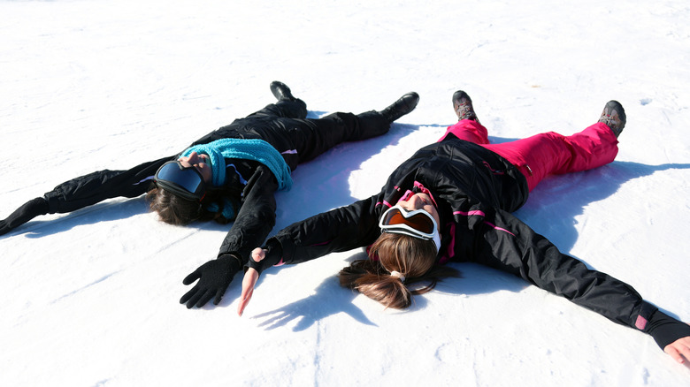 Skiers making snow angels after a hard day's skiing.