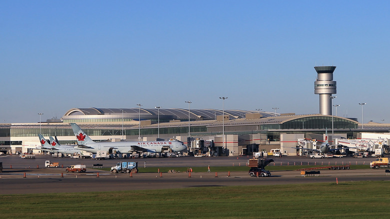 Outside view of airplanes and air traffic control tower at Toronto's Pearson International Airport (YYZ)