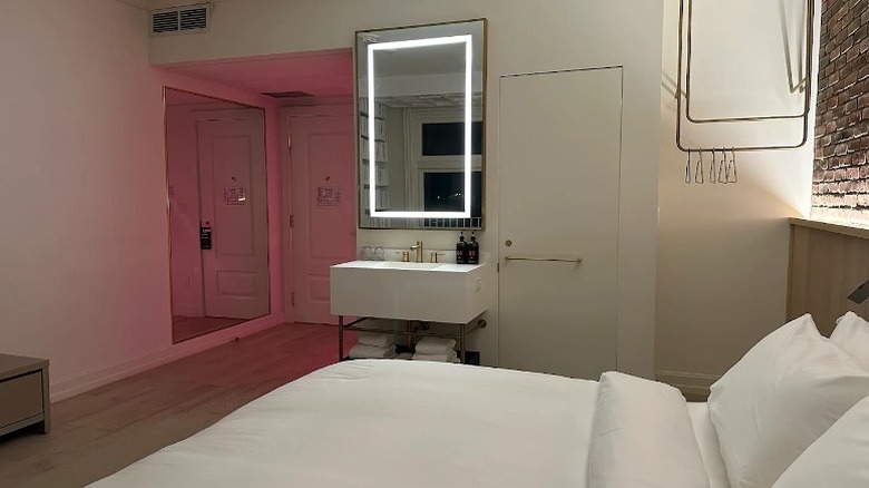 A small room with white bedding and exposed bricks at Gladstone House in Toronto.