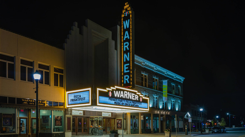 Warner Theatre lit up at nighttime in Torrington, Connecticut, against a dark night sky.
