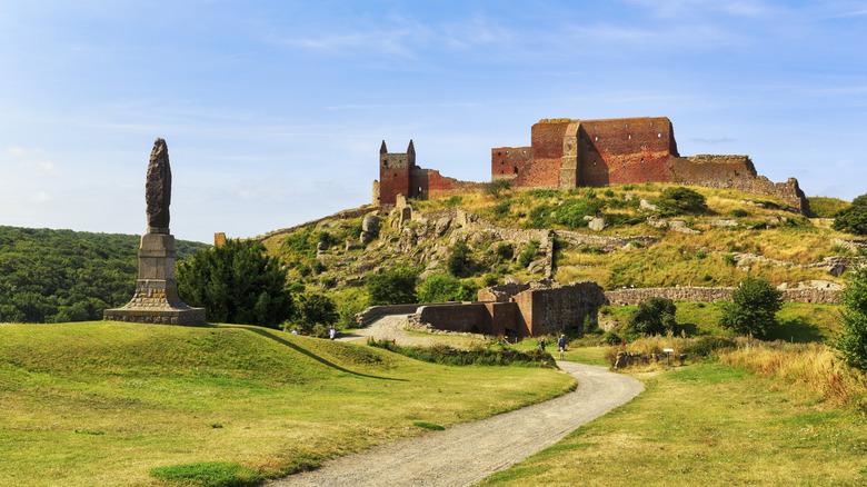View of Hammershus castle ruins, perched atop a hill, on Bornholm Island in Demark on a bright day