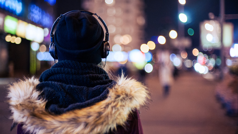 Back view of person walking at night in a city