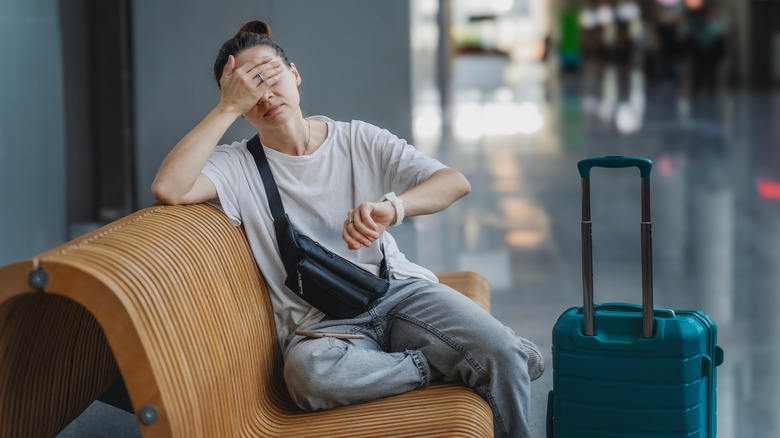 A woman is stressed about time at the airport