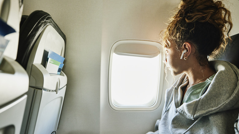 Woman looking out a plane window