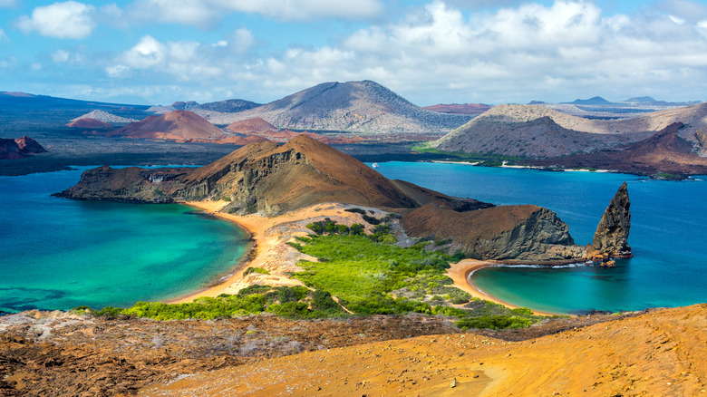 Tuquoise waters, sandy beaches with their backs conjoined, hilly beach, hills in the backdrop