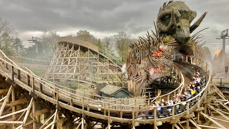 Spiral roller coaster with visitors riding inside cars