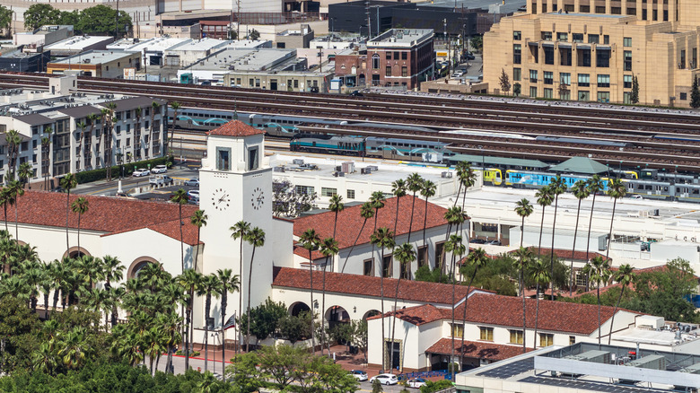 Aerial view of L.A. Union Station surrounded by palm trees with train tracks in the background