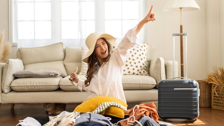 A smiling woman packing her luggage