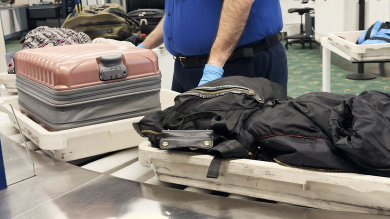 Carry-on luggage on the conveyer belt at a TSA checkpoint