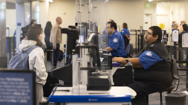 Asian female traveler has her ID documents checked with the TSA at the San Jose International Airport.