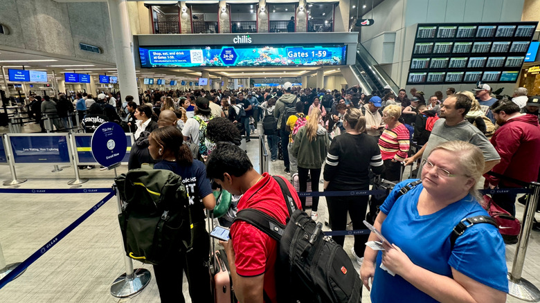 Crowds of people lining up for TSA security screening at Orlando International Airport.
