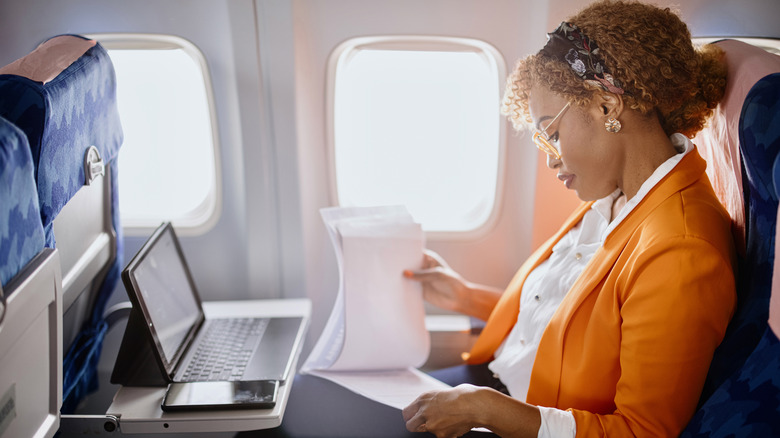 A business woman using a tablet in flight